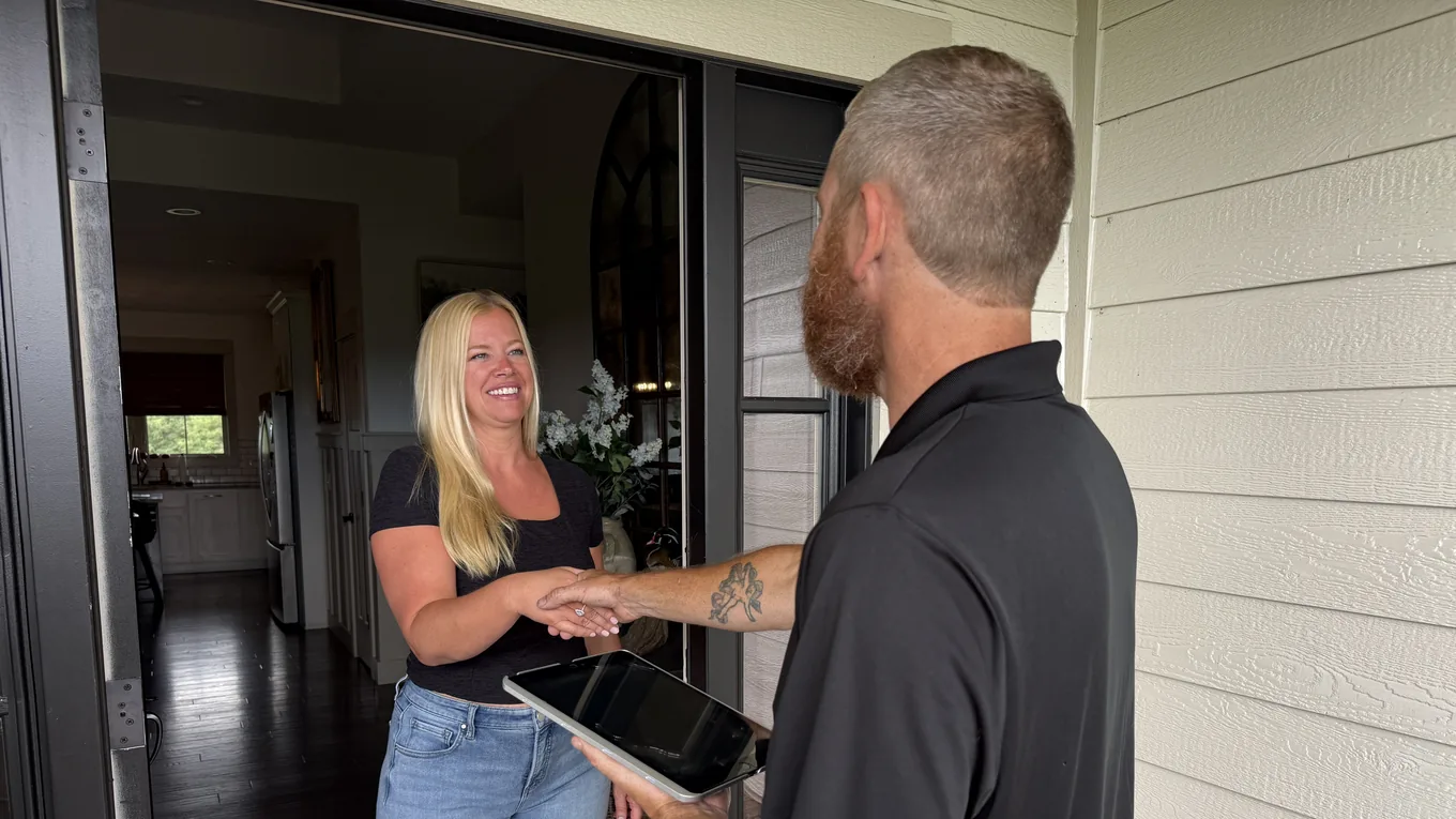 A smiling PROJUNK customer shaking hands with a crew member after a same-day job in Louisville
